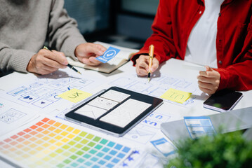 Close up view of UI developer team brainstorming on their project with laptop, smartphone and digital tablet
