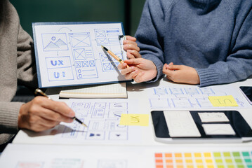 Creative UX UI team designing website wireframes, templates, and color systems with digital tools and real people in a tech office environment.