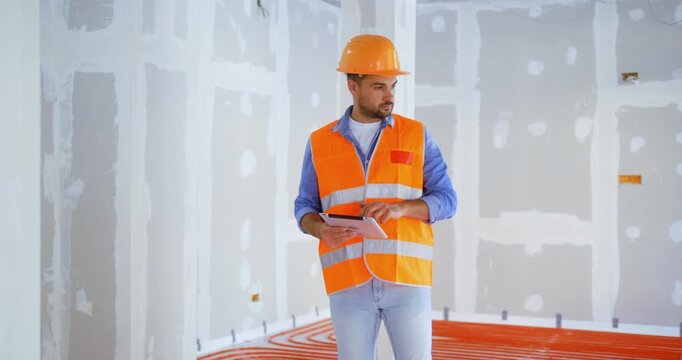 Construction inspector checks the quality of the work using a digital tablet on the construction site. Construction and safety rules before commissioning.