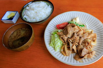 ご飯と味噌汁が付いた生姜焼き定食
炒めた豚肉の生姜焼きを野菜と一緒に盛り付け、ご飯と味噌汁、漬物が付いた日本の定食料理です。
