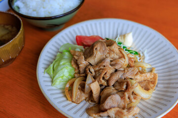 ご飯と味噌汁が付いた生姜焼き定食
炒めた豚肉の生姜焼きを野菜と一緒に盛り付け、ご飯と味噌汁、漬物が付いた日本の定食料理です。
