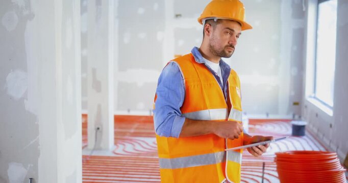Construction inspector checks the quality of the work using a digital tablet on the construction site. Construction and safety rules before commissioning.