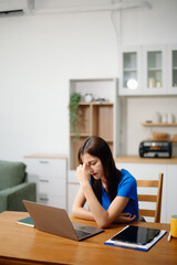Asian business woman is stressed, bored, and overthinking from working on a tablet