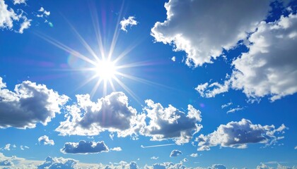 Azure sky vista filled with fluffy, white cumulus clouds, shining sun with vibrant starburst effect casting rays