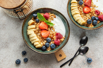 Healthy breakfast bowls with yogurt, granola, berries and banana slices © Olena Rudo