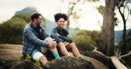 Happy, couple and relax from hiking in nature with partner, travel adventure and bonding on holiday trip. Smile, people and rest on mountain for sightseeing, trekking break and backpacking vacation