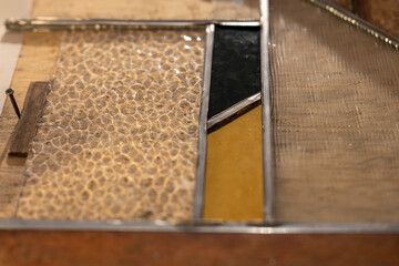 Gros plan sur des vitraux colorés, révélant les détails du verre et des motifs artisanaux.