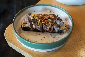 Close up plate of grilled Wagyu beef and mushroom on toast