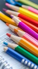 Fototapeta premium Colorful pencils clustered together on a spiral-bound notebook