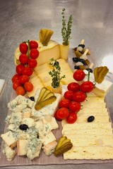 Gourmet Cheese Plate with Pickles, Tomates, and Assorted Delicacies

