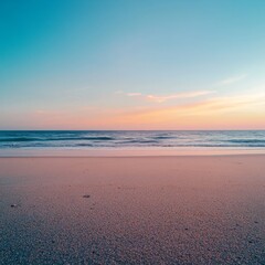 Close-up of beach sand with a clear blue summer sky above. Wide view of an empty, calm beach. Warm sunset colors the sky, creating a peaceful and relaxing summer scene.
