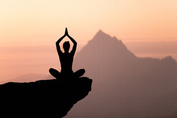 Meditative Silhouette of a Person Practicing Yoga at Sunset