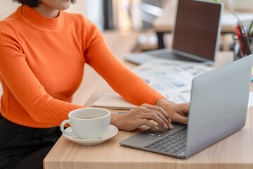 Business woman working on laptop or notebook in her office.