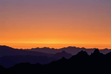 Fototapeta premium Silhouetted mountain ranges fade into a vibrant orange and purple sunset sky.