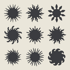 Abstract black sun shapes with various ray designs on light background