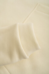Obraz premium Hoodie texture. Close-up of the sleeve of a yellow hoodie. Cotton. Warm textile fabric, macro.