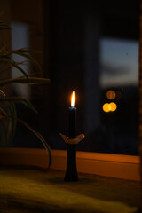 Cozy and dark Christmas morning, vintage candles on the window sill 