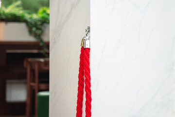 red retractable barrier rope in an open position on a wall at a venue where celebrities gather for...