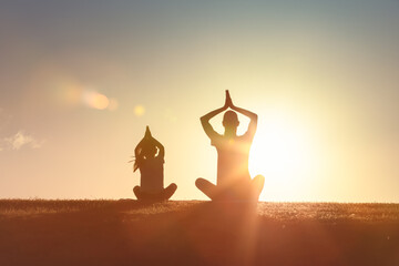Young mother and little daughter meditating in lotus pose together, Healthy Family Lifestyle, Life Balance
