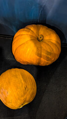 Two pumpkins on a wooden background, autumn background.