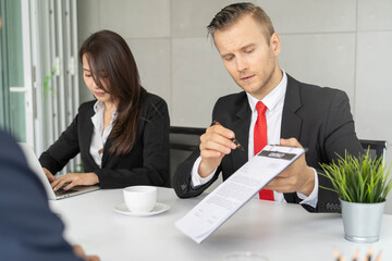Dealer agent explaining contract information to client in meeting room.