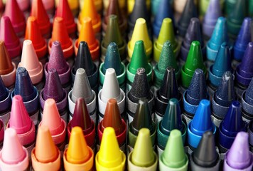 Rows of colorful crayons arranged closely, showing a spectrum of hues, sharp points, and various shades, creating a vibrant artistic composition
