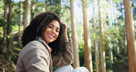 Happy woman, portrait and relax in woods for nature adventure, happiness and traveling holiday. Morning trip, hiking and relaxed person with smile in forest, explore or wellness for outdoor exercise