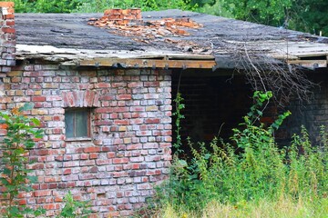 A ruined historic brick forge building with a damaged roof and chimney, Siedlce district of Gdansk