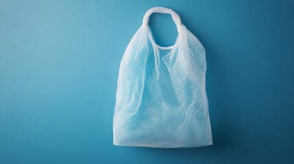 Food packaging: A white net bag against a blue wall.  This plastic snack bag sample is perfect for your design.
