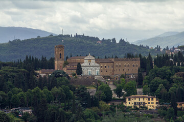Obraz premium Panoramic view of San Miniato al Monte, a historical abbey in Florence, Italy, nestled on a hillside with surrounding cypress trees, perfect for travel, cultural, or architectural designs.