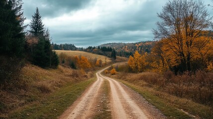 Obraz premium Autumnal dirt road winds through a valley