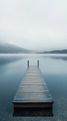 Fototapeta premium Misty lake scene with a wooden pier extending into the water