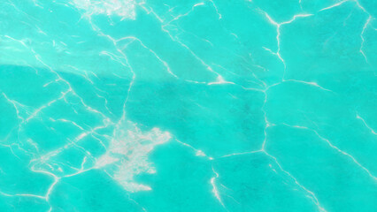 Abstract turquoise background resembling water surface with veins creating a luxurious marble texture suitable for decorative designs and artistic applications.