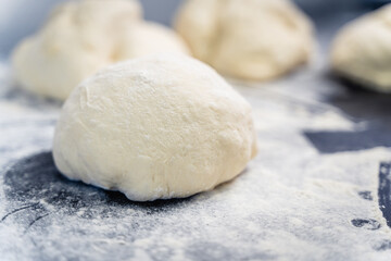 A piece of dough is sitting on a counter with a lot of flour on it