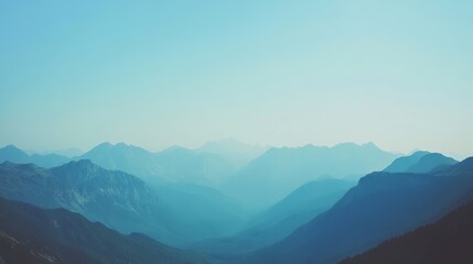 Obraz premium Panoramic view of distant mountain ranges, soft blue tones, hazy atmosphere