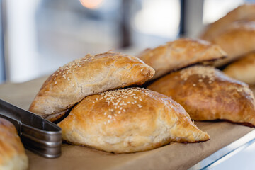 A tray of pastries with sesame seeds on top