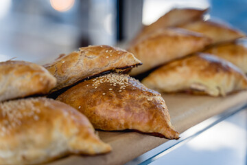 A tray of pastries with sesame seeds on top