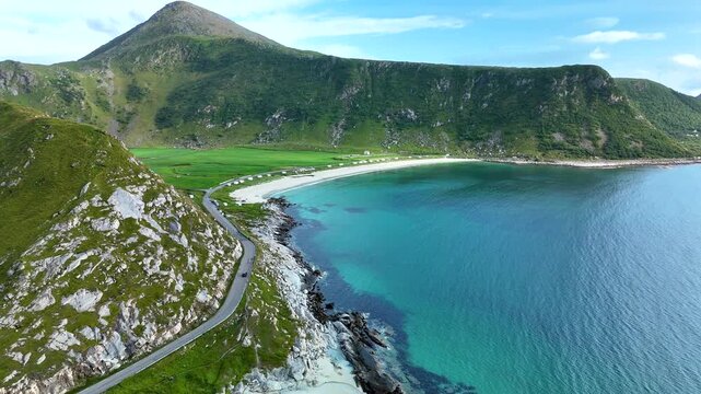 Experience the breathtaking beauty of Lofoten Norway with its vibrant turquoise waters and lush green hills. Mannen Haukland beach