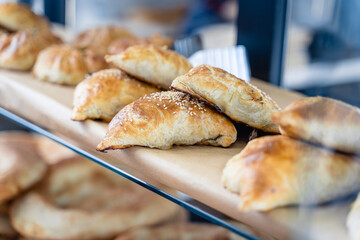 A row of pastries on a counter, including some that are shaped like donuts
