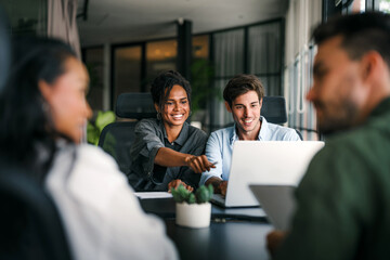 Diverse startup, business people working together on laptop computer in modern office
