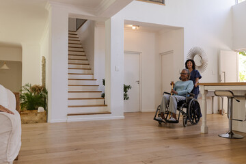 Senior man in wheelchair enjoying conversation with friend at home