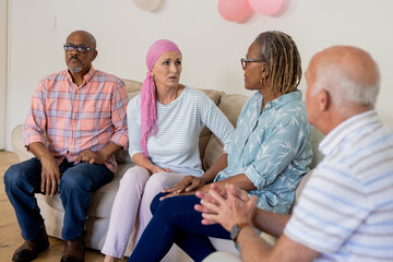 Senior friends having heartfelt conversation on couch, supporting each other warmly