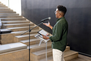 African American man presenting with tablet at modern office, engaging audience