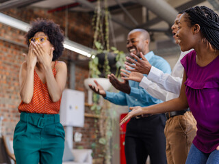 Celebrating success, African American colleagues expressing excitement and joy in office