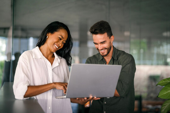 Two happy diverse multiethnic business team people working, talking in corporate office - Powered by Adobe
