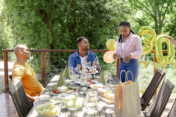 Celebrating outdoors, friends enjoying birthday party with food and decorations