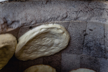 Uzbek flatbread whist on hay of tandoor and get ready. Cakes are ruddy and juicy, with appetizing crust