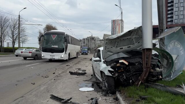 Severely damaged car, accident on city road. Car crashed into a pole, front part is destroyed, hood is open. Concept of accident, danger on the road and insurance. 