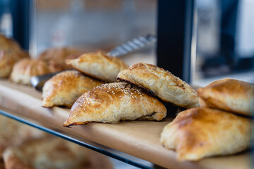 A row of pastries on a counter, including some that are shaped like donuts