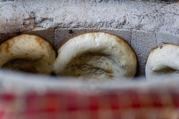 Uzbek flatbread whist on hay of tandoor and get ready. Fire is burning below. Cakes are ruddy and...